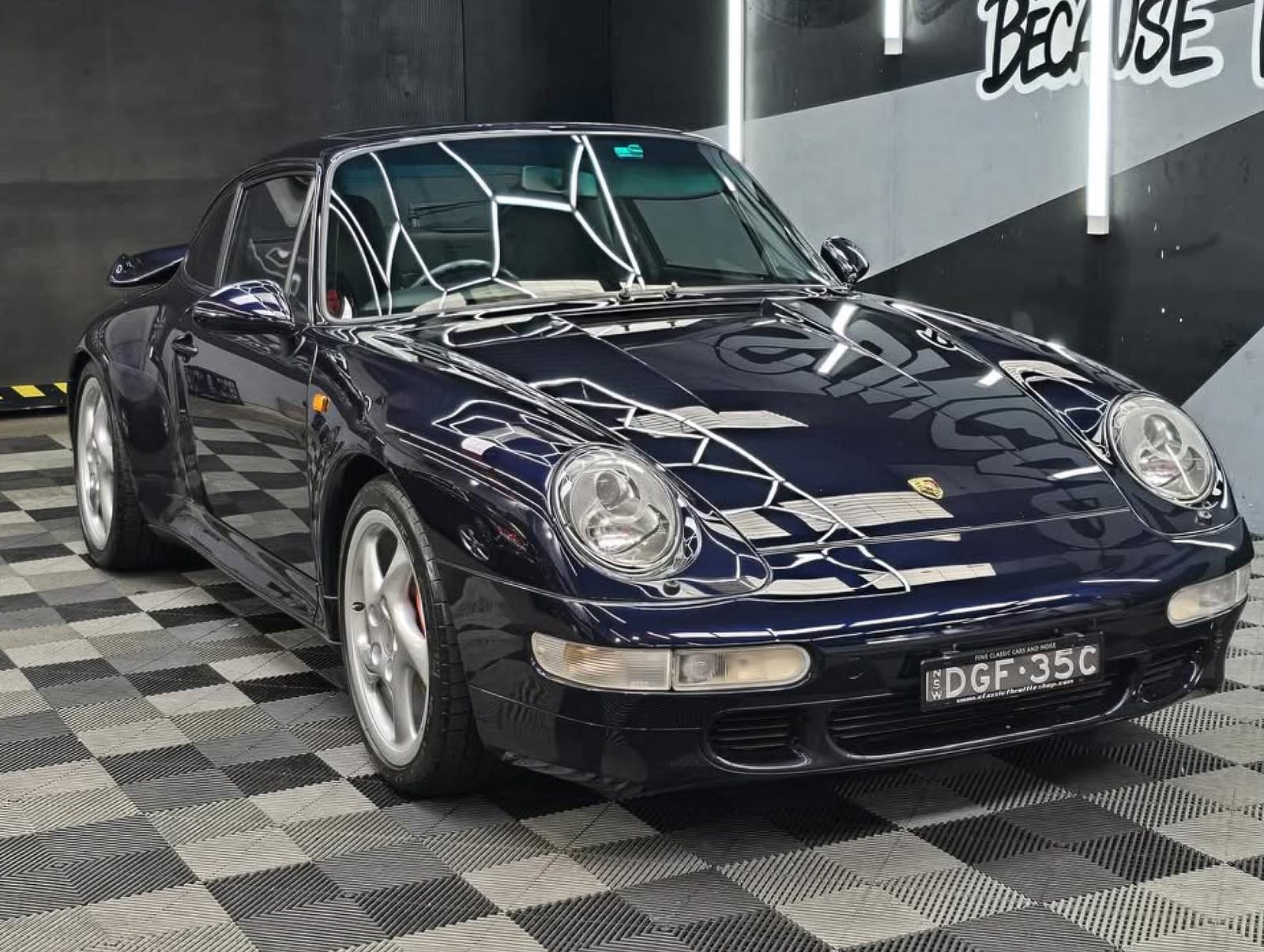 Classic Porsche 911 in the bay, SunCare mural behind